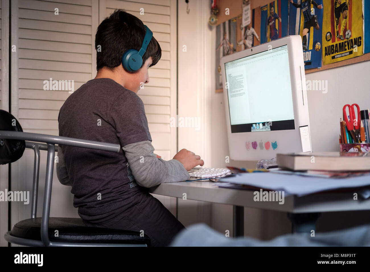 Surrey, Großbritannien. 10 Jahre alter Junge auf dem Computer in seinem Schlafzimmer - Seitenansicht Stockfoto