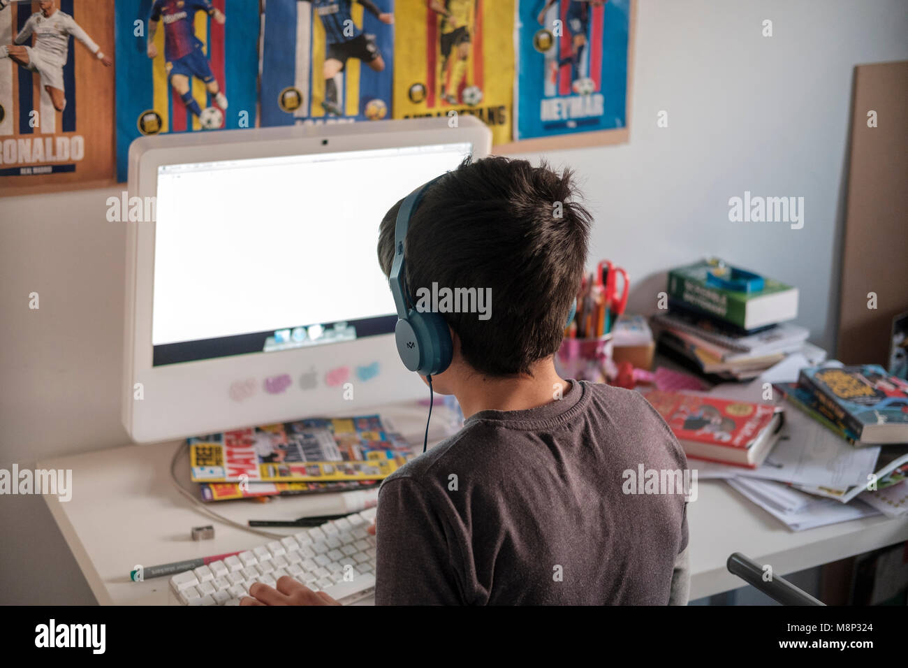 Surrey, UK, 10 Jahre alter Junge auf dem Computer in seinem Schlafzimmer - Rückansicht Stockfoto