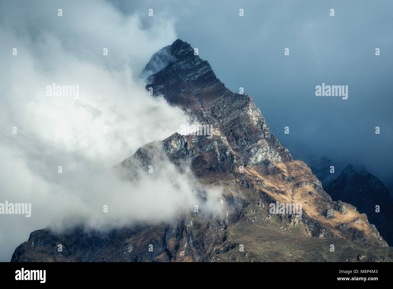 Berge in Wolken bedeckt Abend in Nepal. Landschaft mit schönen hohen Felsen und dramatische bewölkter Himmel bei Sonnenuntergang. Natur Hintergrund. Fairy Szen Stockfoto