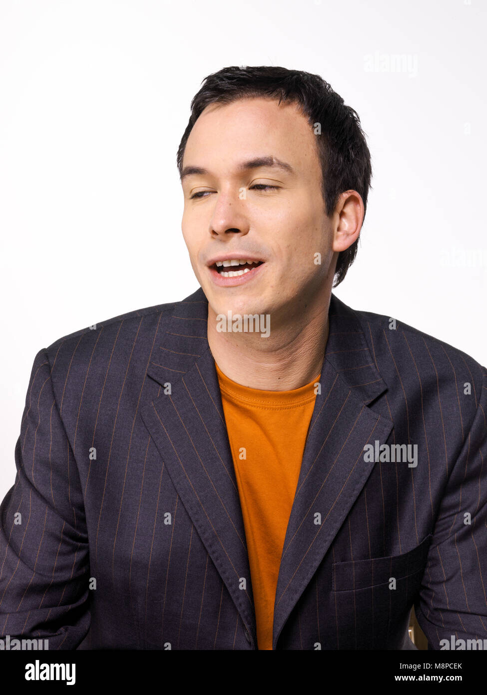 Studio Portrait der jungen weißen Mann/Mann mit dunklem Haar gegen den hellen Hintergrund Stockfoto