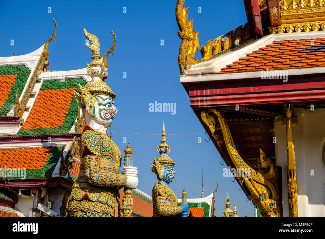 Der Dämon Wächter sind durch kunstvolle Gebäude im Grand Palace umgeben Stockfoto