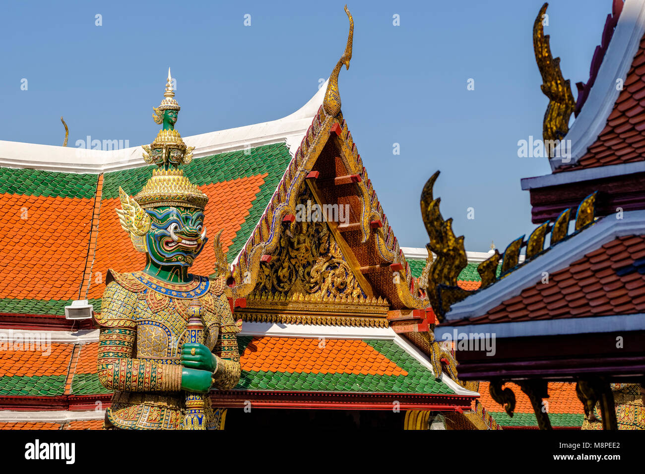 Der Dämon Wächter sind durch kunstvolle Gebäude im Grand Palace umgeben Stockfoto