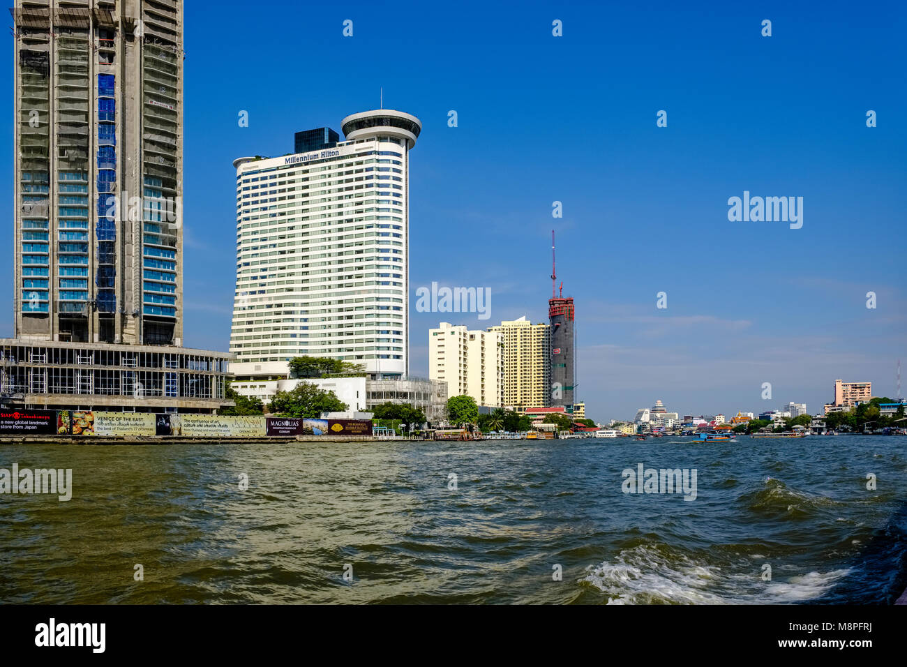 Blick über den Fluss Chao Phraya auf der Baustelle von Iconsiam und das Millenium Hilton Hotels in der Innenstadt von Stockfoto