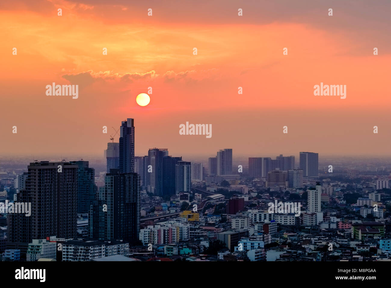 Die Sonne ist hinter den Hochhäusern des westlichen Teils der Stadt Stockfoto