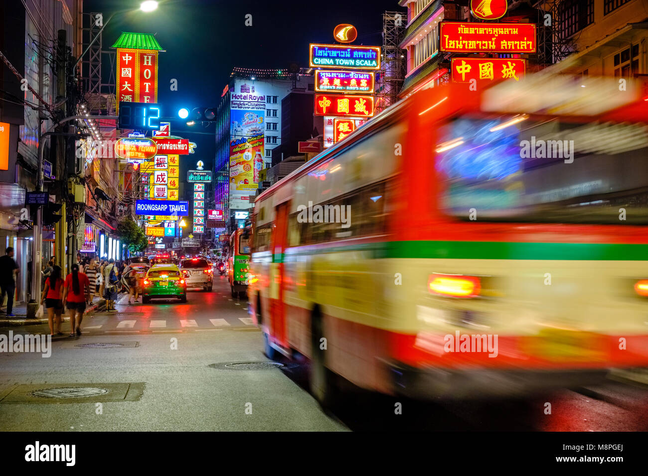 Street Scene mit Autos, Bussen und viele Werbespots in Chinatown, beleuchtet bei Nacht Stockfoto