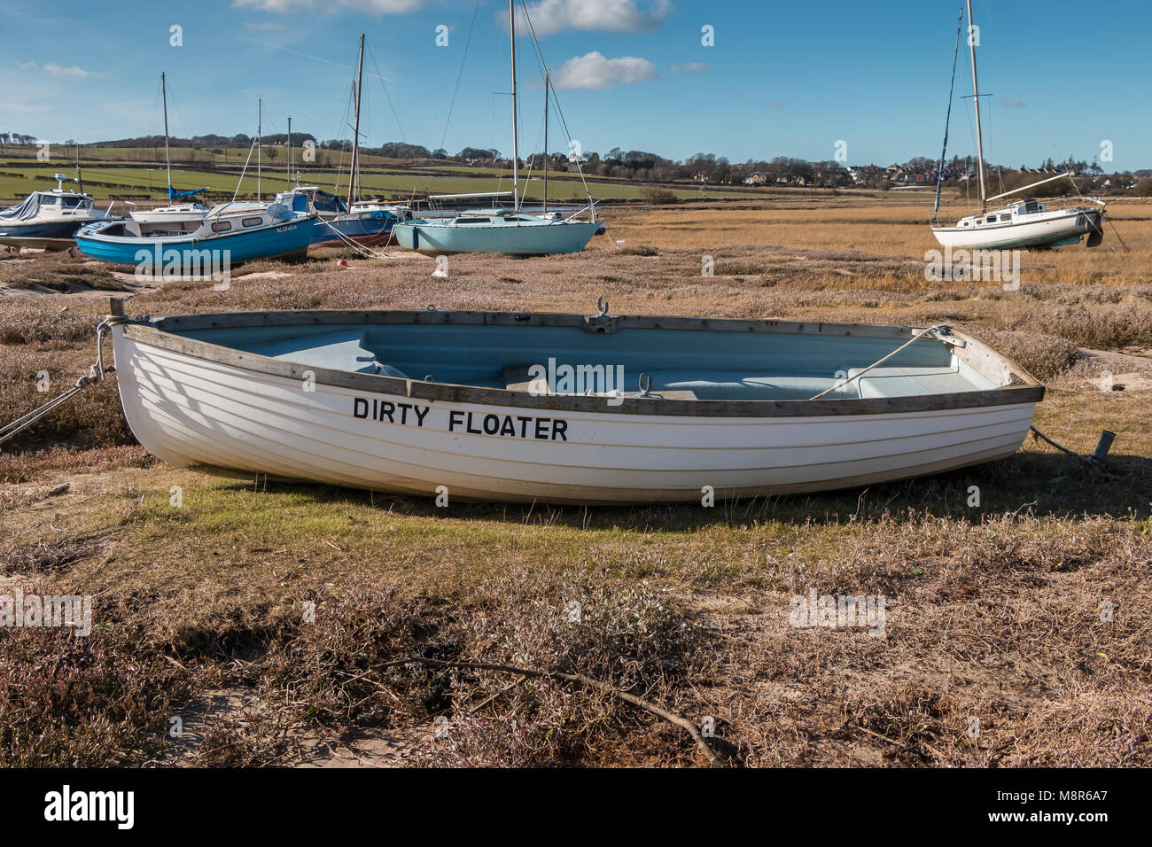 Beiboot mit lustigen Namen dreckig Floater im Alnmouth Hafen, Northumberland Küste AONB, bei Ebbe mit anderen Boote im Hintergrund günstig Stockfoto