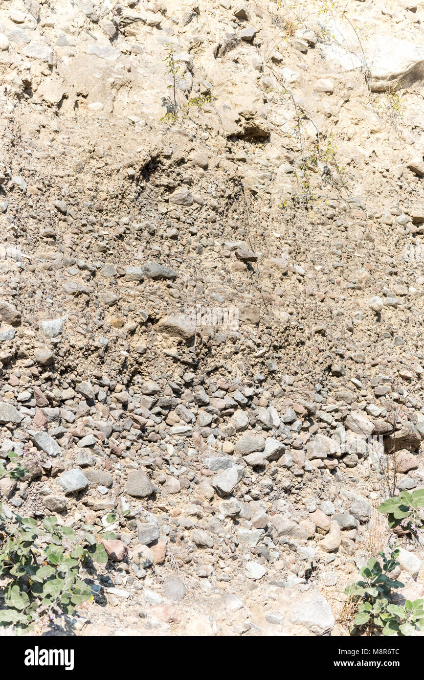 Schnitt durch ein Konglomerat Cliff zeigt die Schichtung Wirkung, wenn sie Steine im Wasser abgelagert Stockfoto
