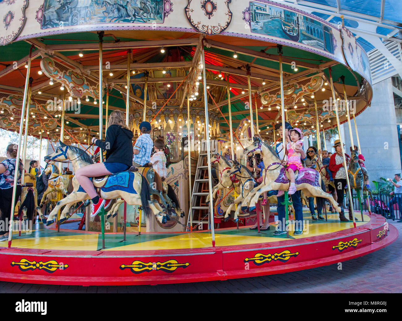 Merry go round Fahrt mit Kindern und Erwachsenen gehen für eine Fahrt. Darling Harbour. NSW. Australien Stockfoto