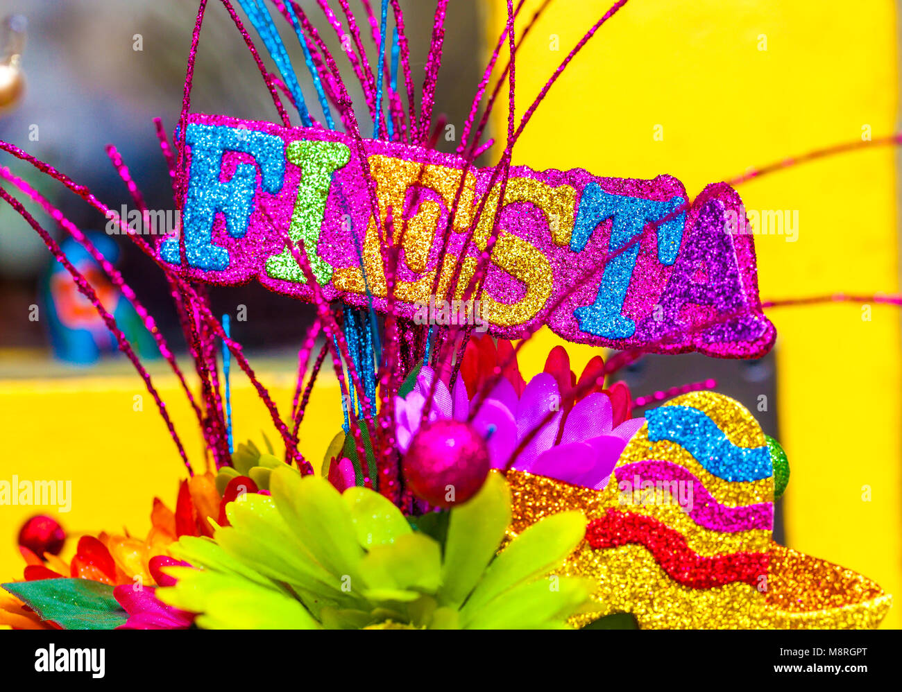 Das Wort 'Fiesta' in bunten glitter Buchstaben mit Sombrero und Papier Blumen geschrieben Stockfoto