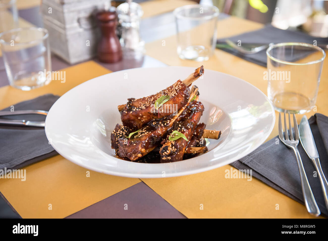 Schüssel, würzig marinierte Rippchen gewürzt mit Gewürzen und frischen Kräutern in einer förmlichen Tisch im Restaurant serviert. Stockfoto
