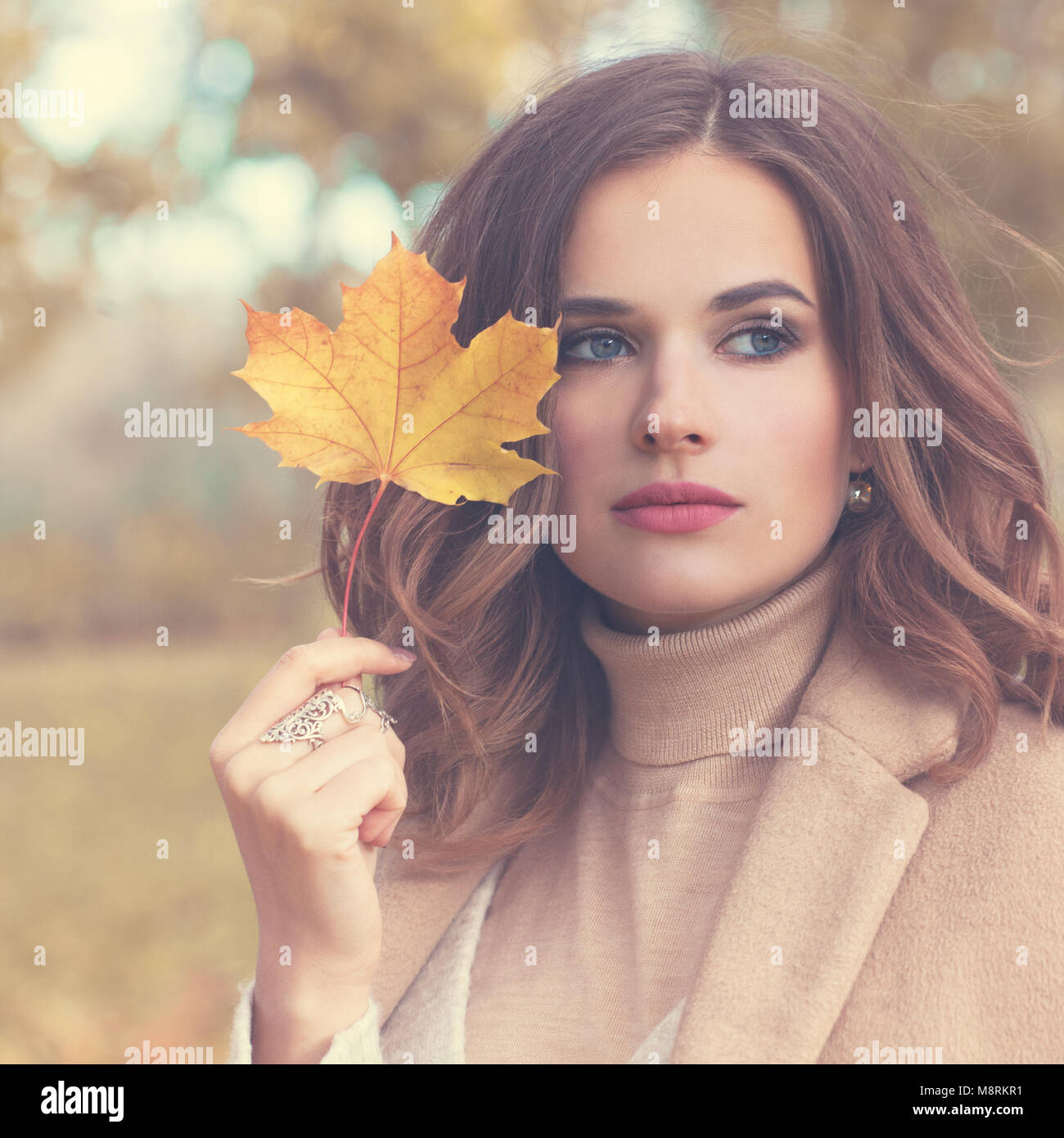 Herbst Fashion Model Frau mit gewelltes Haar und Fall Mapple Leaf im Freien Stockfoto