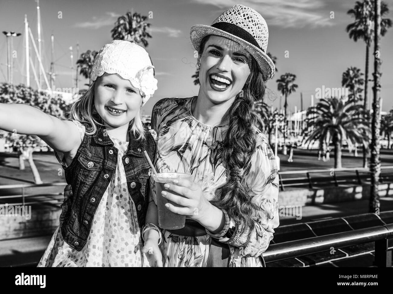 Sommer am bunten Barcelona. lächelnd elegante Mutter und Tochter Reisende in Barcelona, Spanien mit leuchtend roten Trinken unter selfie Stockfoto