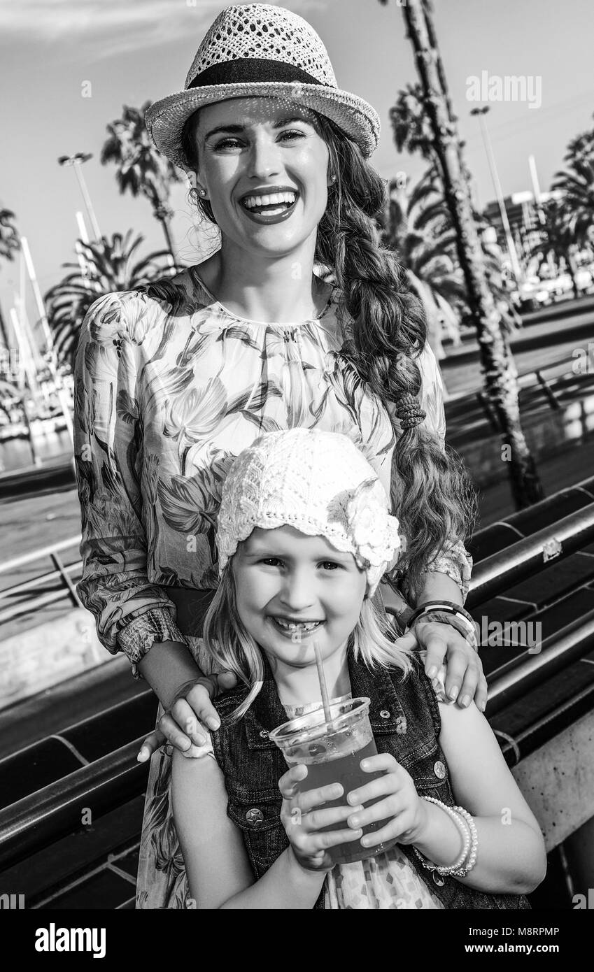 Sommer am bunten Barcelona. lächelnden jungen Mutter und Kind die Reisenden am Bahndamm in Barcelona, Spanien mit leuchtend roten Trinken Stockfoto