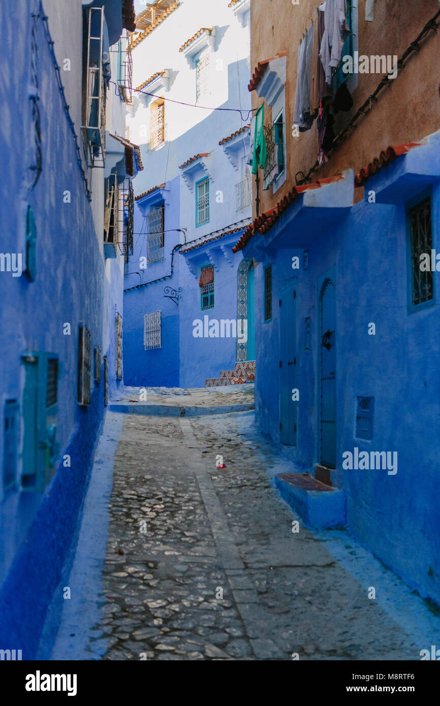 Leere Gasse inmitten blauen Gebäude in Marokko Stockfoto