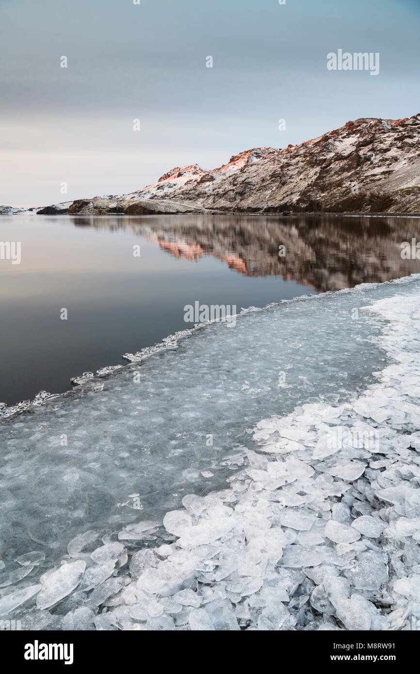 Malerischer Blick auf den See von Bergen mit Eis im Vordergrund Stockfoto