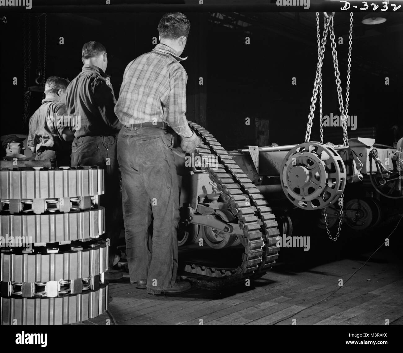 Gruppe der Arbeitnehmer die Traktor Riemen auf Chassis von der Armee Half-Track Scout Auto im Werk umgewandelt in der Kriegsproduktion, White Motor Company, Cleveland, Ohio, USA, Alfred T. Palmer für Office of War Information, Dezember 1941 Stockfoto