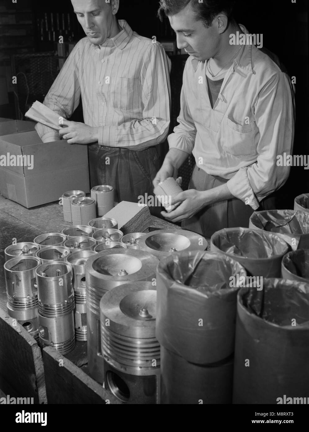 Zwei Arbeiter Verpackung fertigen Kolben Geplant in der Armee Jeeps verwendet werden, hergestellt in Aluminium Fabrik umgewandelt in der Kriegsproduktion, Aluminium Industries, Inc., Cincinnati, Ohio, USA, Alfred T. Palmer für Office of War Information, Februar 1942 Stockfoto