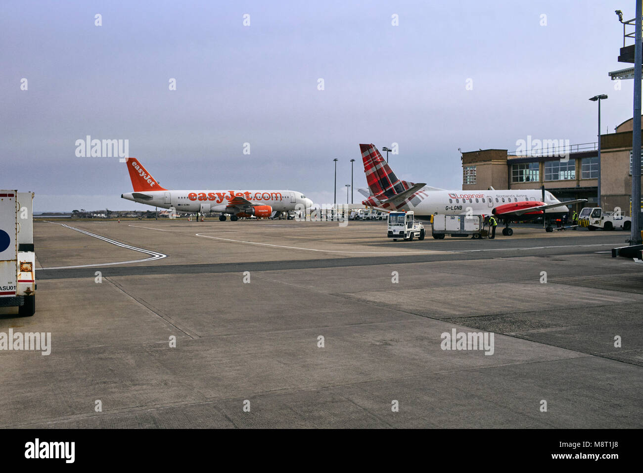 EasyJet und Loganair Flugzeuge auf der Start- und Landebahn am Flughafen Ronaldsway auf der Insel Man Stockfoto