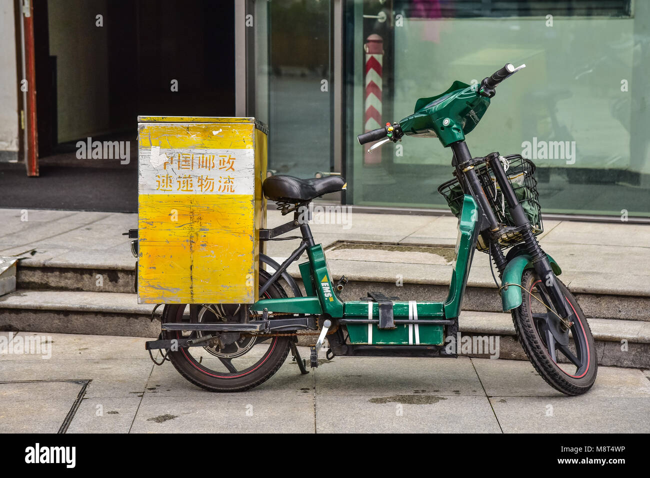 Eine alte grüne Scooter mit einem hölzernen Aufbewahrungsbox zurück. Eine Lieferung Fahrrad in China. Stockfoto