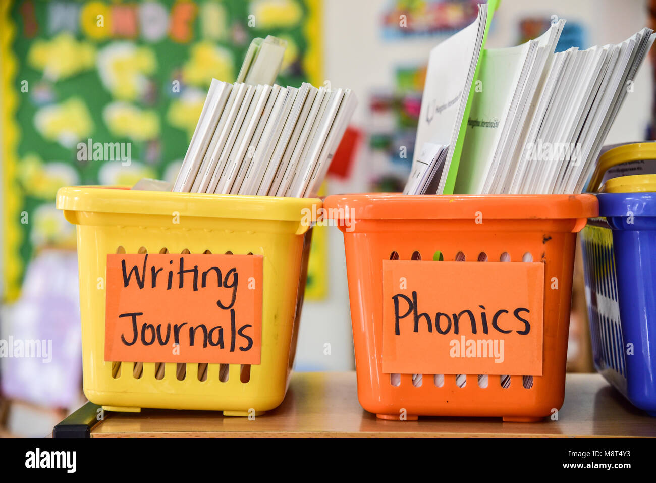 Zwei helle, farbenfrohe Körbe in der frühen Kindheit Klassenzimmer. Man sagt," schreiben Zeitschriften' und der andere sagt "phonics". Stockfoto