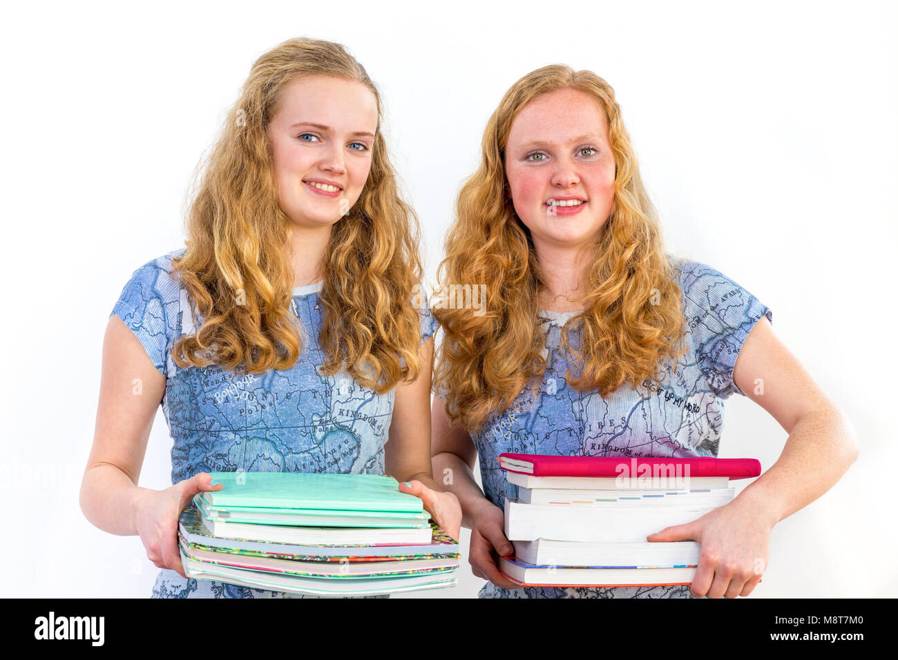 Zwei Schüler holding Haufen Lehrbücher isoliert auf weißem Stockfoto