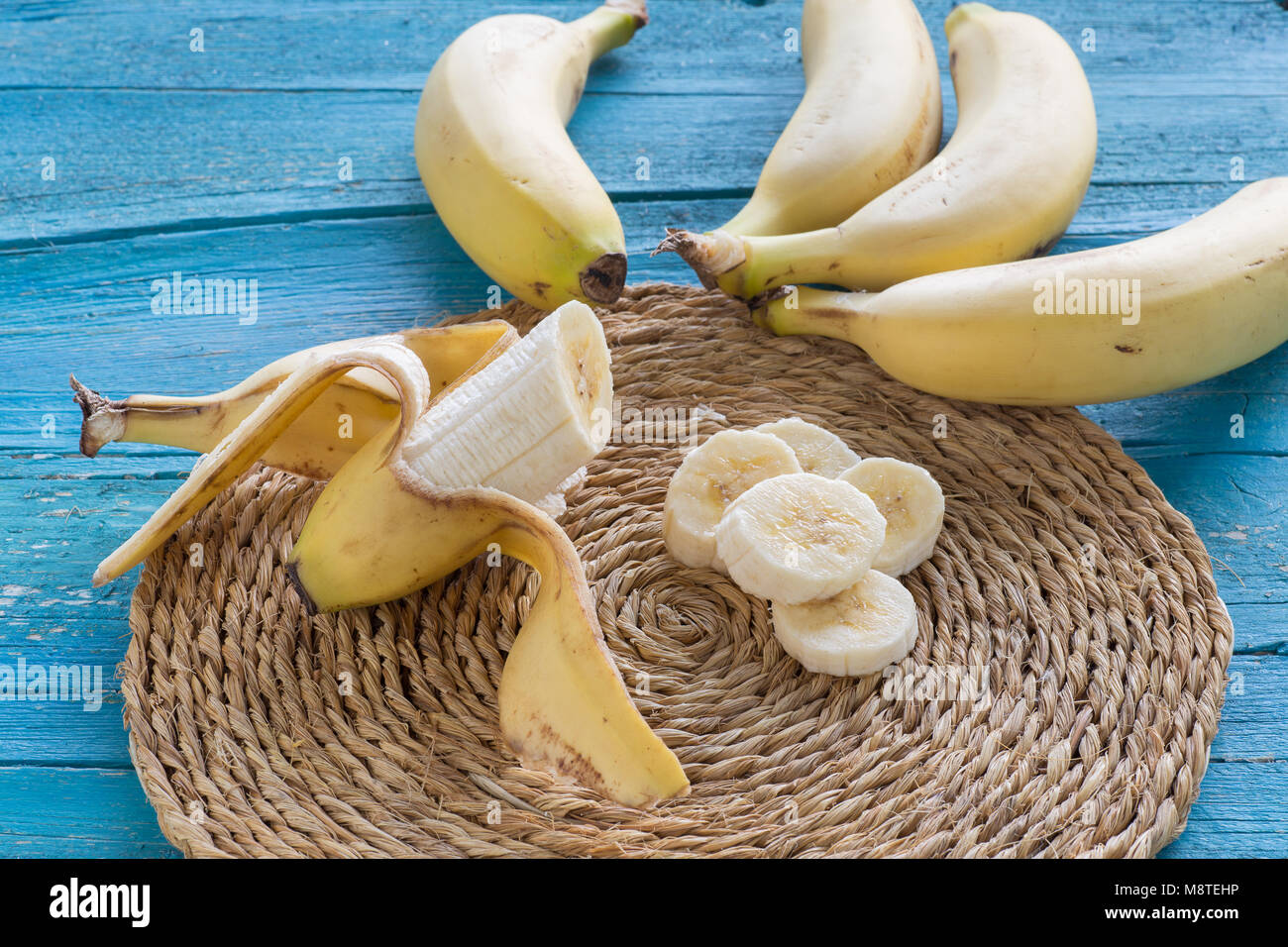 Eingestellt von Bananen in Scheiben geschnitten auf einer Platte auf Blau Holz- Hintergrund Stockfoto