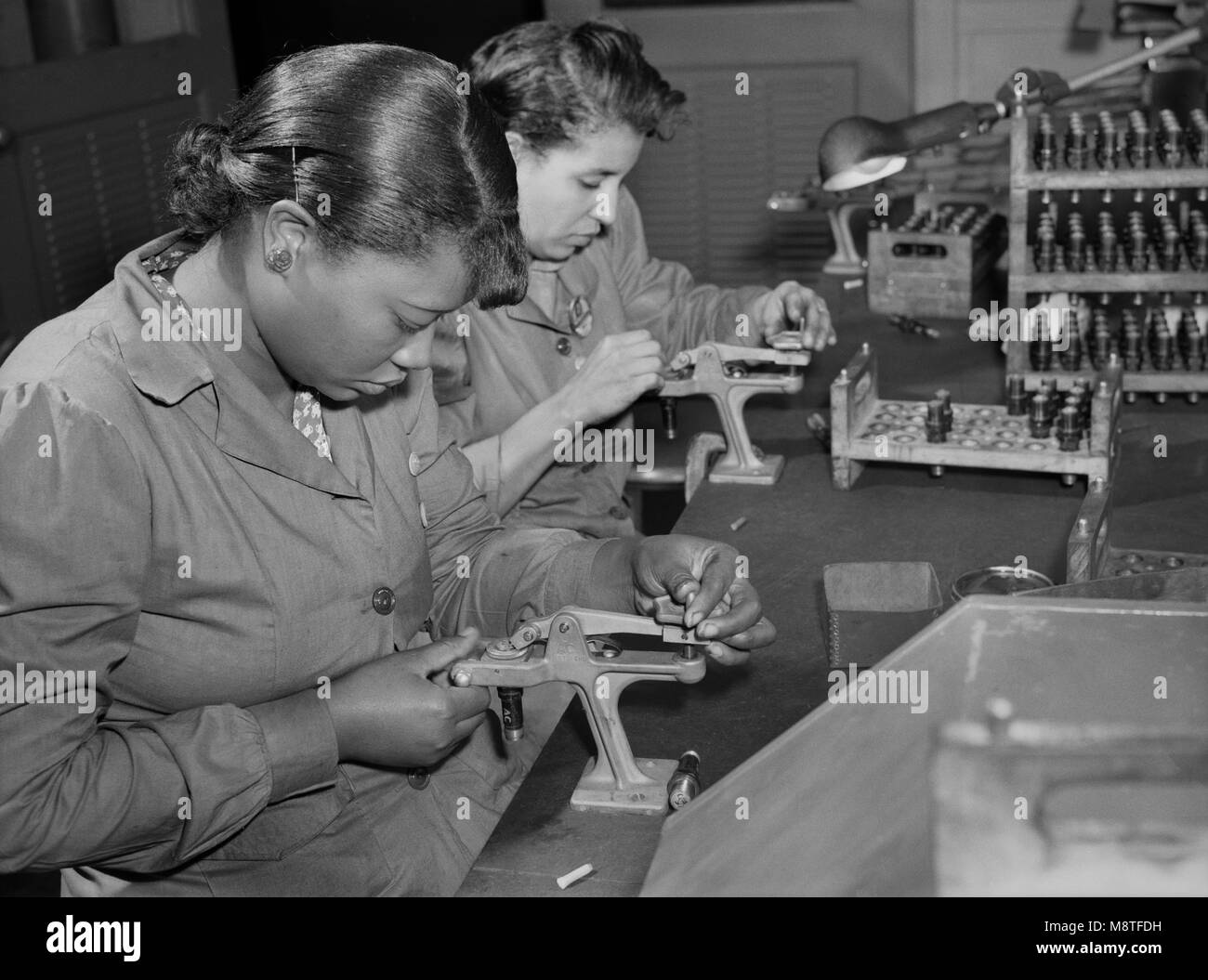 Zwei weibliche Fabrikarbeiter Aufarbeitung von gebrauchten Zündkerzen in Testing Military Aircraft Motoren bei Buick Pflanze umgewandelt für Krieg Produkt Produktion, Melrose Park, Illinois, USA, Ann Rosener, Office of War Information, Juli 1942 verwendet Stockfoto