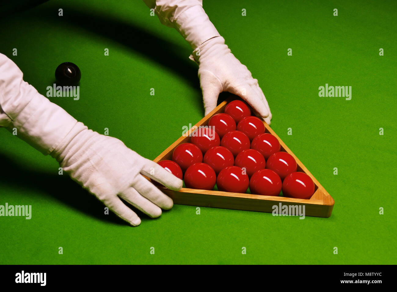 Billardtisch und Kugeln mit Schiedsrichter Hände in weißen Handschuhen die Anordnung der Kugeln im Rack Stockfoto