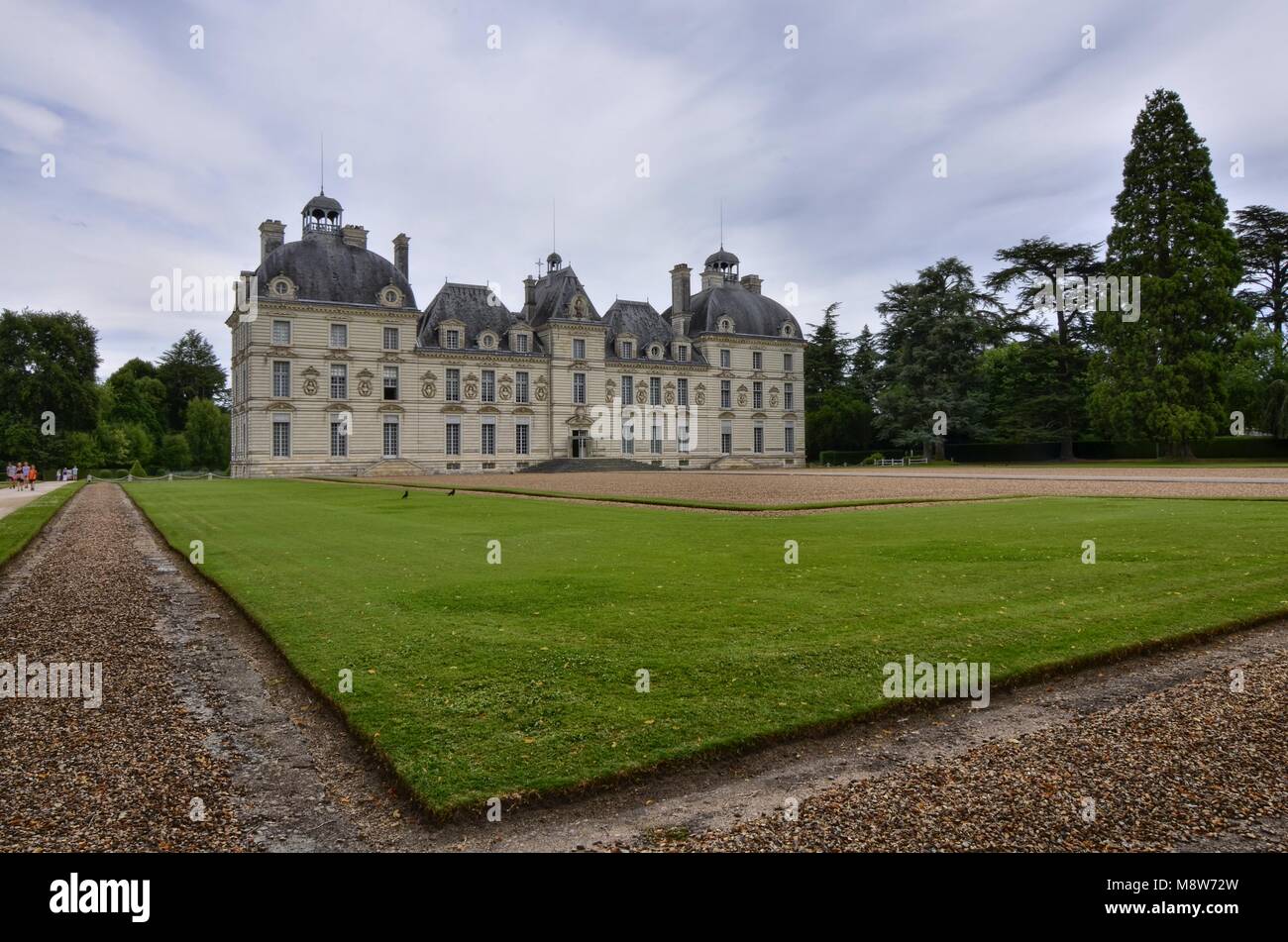 Cheverny, Loire Tal, Frankreich. 26. Juni 2017 um 12:00 Uhr. Ansicht von drei Vierteln auf der linken Seite der Fassade, präsentieren einige Touristen, blauer Himmel mit Stockfoto