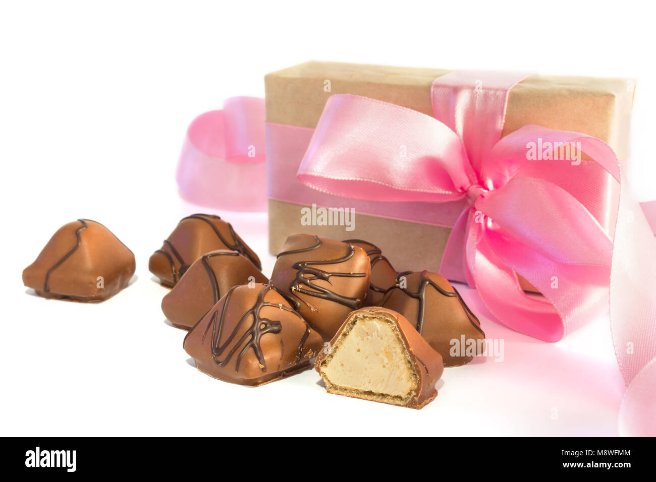 Mehrere dreieckigen Schokolade mit Geschenkbox mit Pink Ribbon auf weißem Hintergrund gebunden Stockfoto