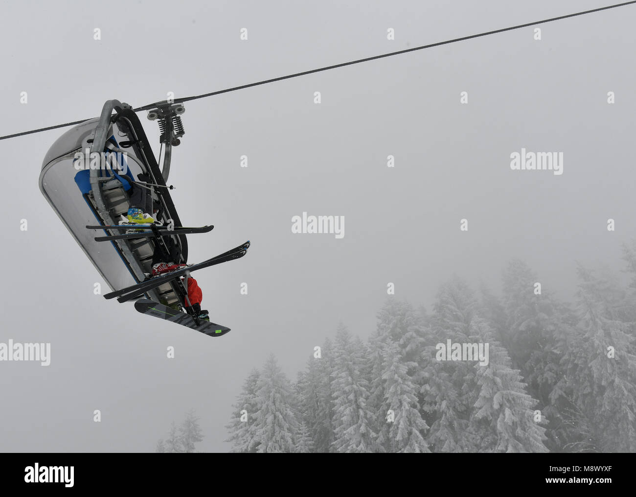20 März 2018, Deutschland, Garmisch-Partenkirchen: Skifahrer in einem Sessellift sitzen im Skigebiet am Anfang des Frühlings. Foto: Angelika Warmuth/dpa Stockfoto