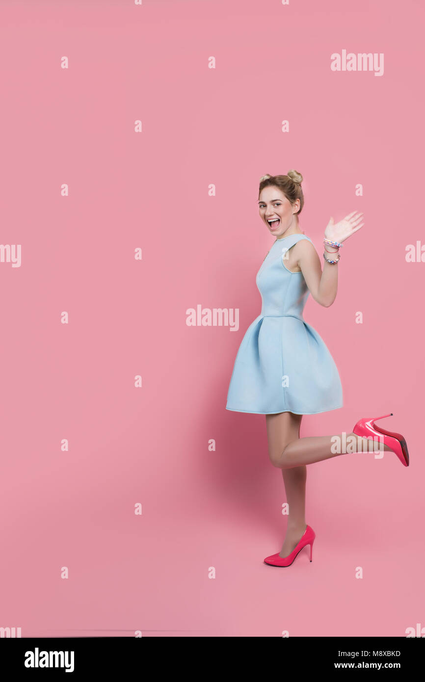 Emotionale Frau in Kleid auf rosa Hintergrund Stockfoto