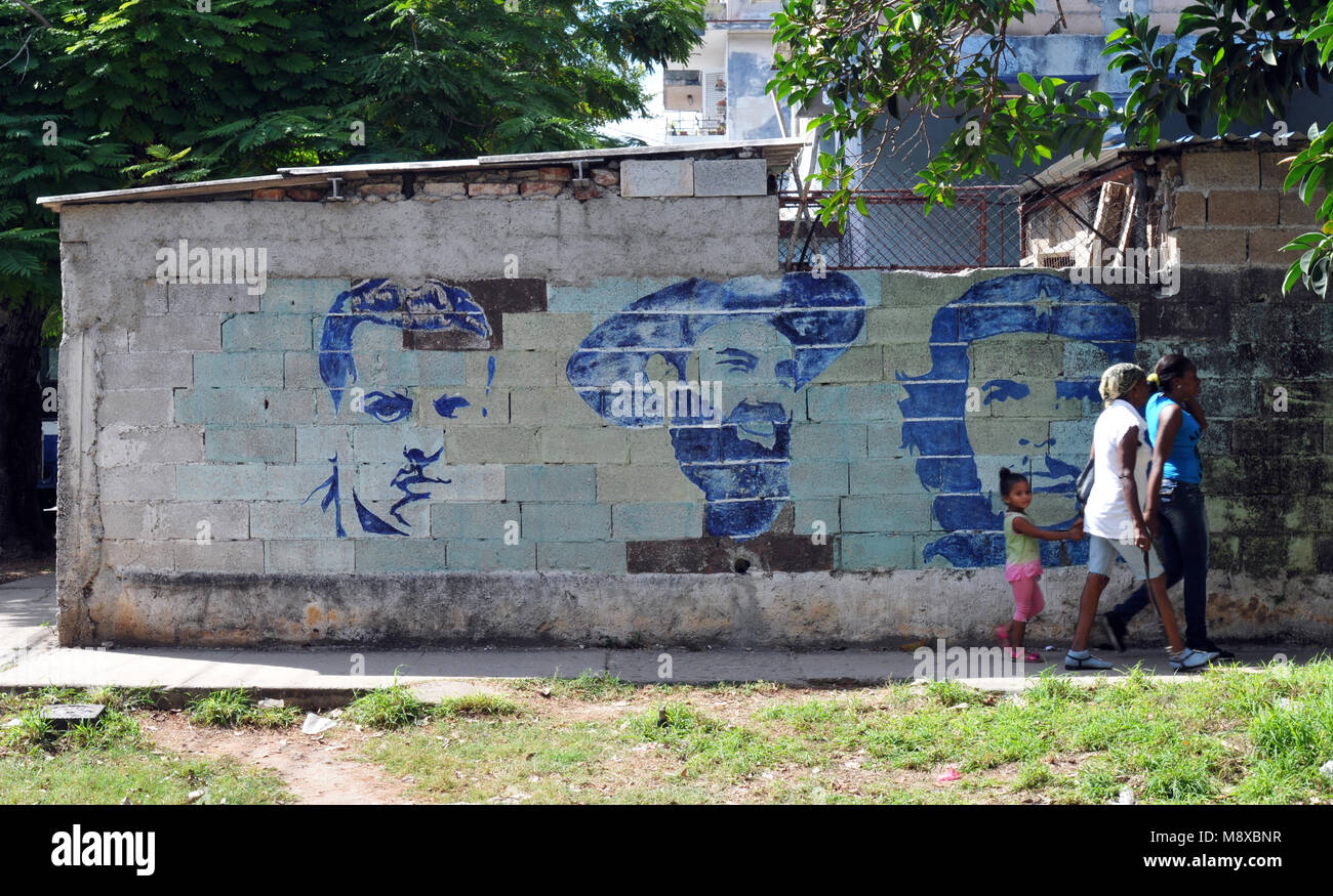 Menschen gehen vorbei Street Art, die kubanischen Revolutionäre Julio Antonio Mella, Camilo Cienfuegos und Ernesto 'Che' Guevara in Havannas Stadtteil Vedado Stockfoto