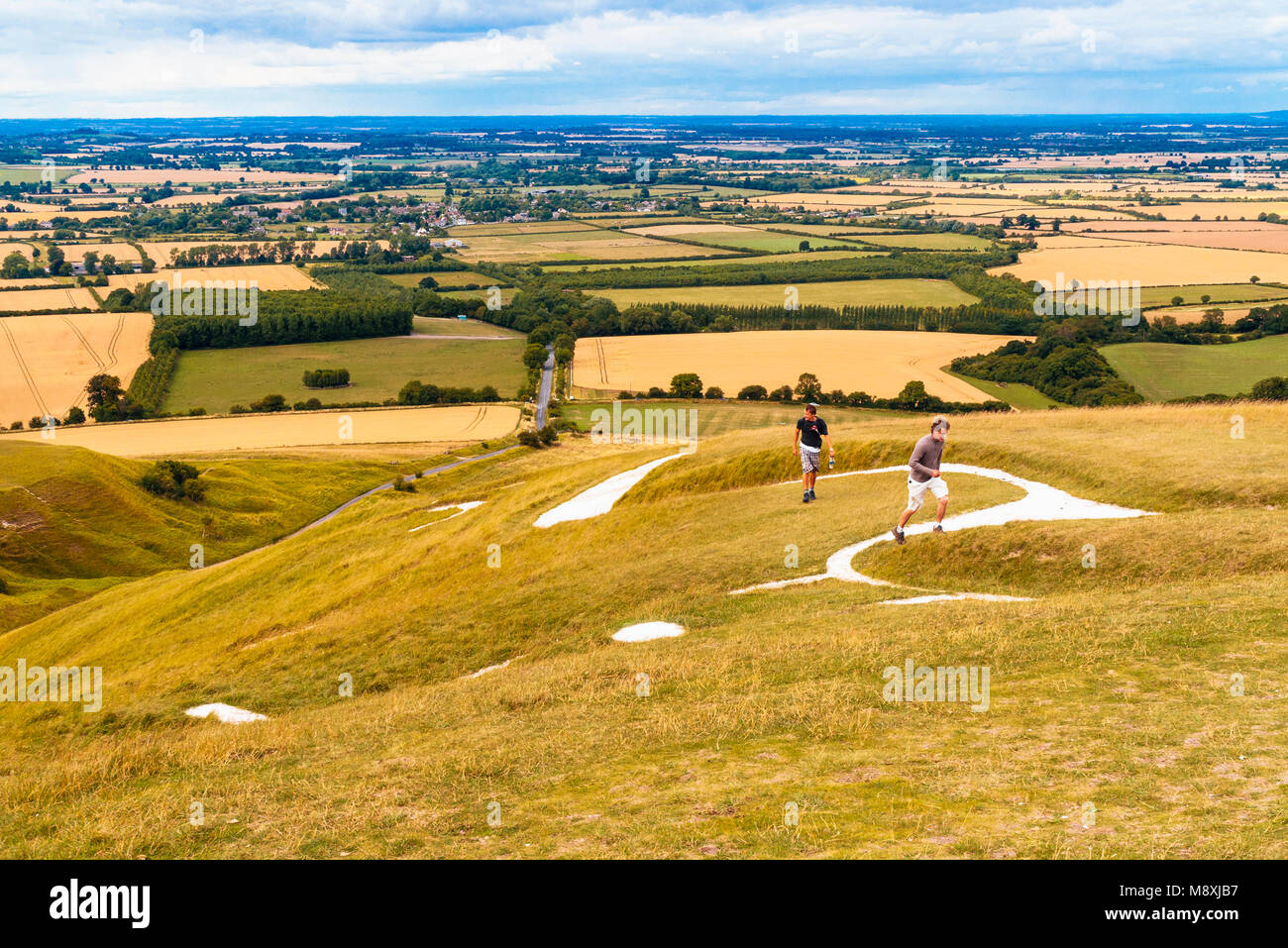 Wanderer auf dem Kopf des White Horse von Uffington, auf der Berkshire Downs in der Nähe von Woodford. Das Tal von White Horse liegt unter Stockfoto