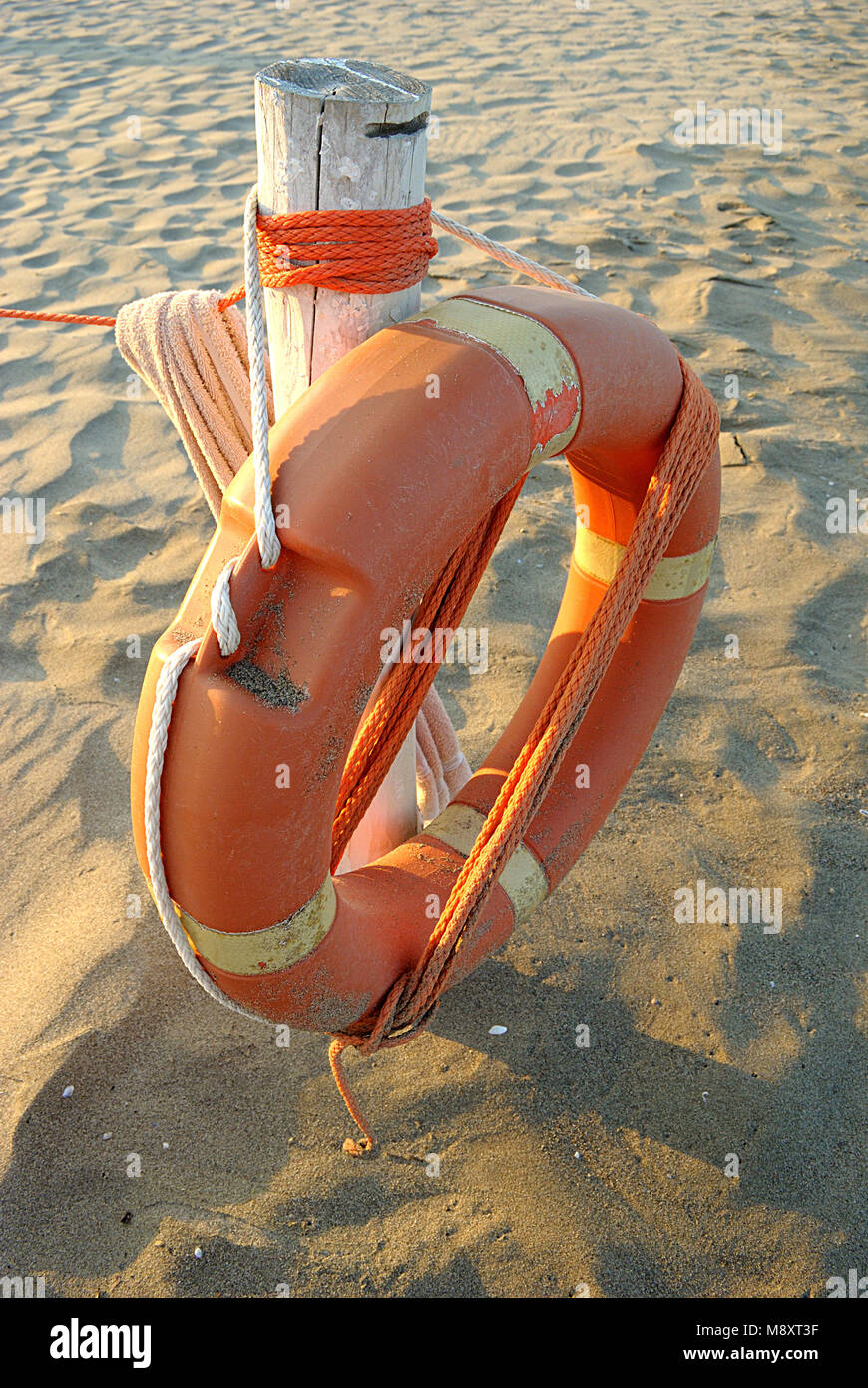 Sommer Meer, bis auf orangefarbenen Rettungsring auf dem Sand in der Nähe, vertikal Stockfoto