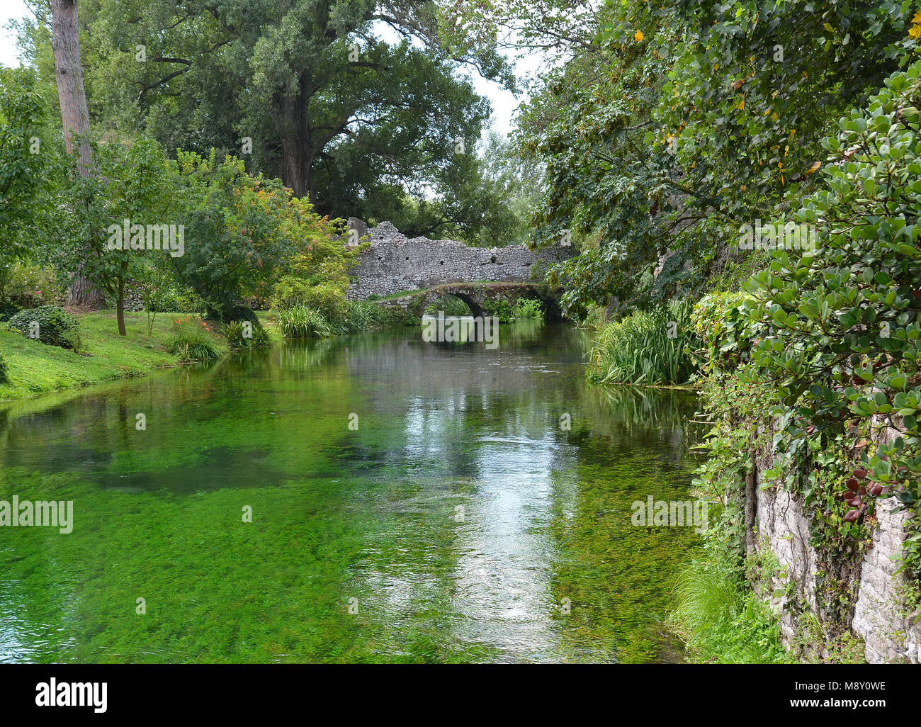 Garten von Ninfa - ein Naturdenkmal mit mittelalterlichen Ruinen in Stein, Blumen Park und ein ehrfürchtiges Torrent mit wenig fallen. Provinz Latina, Italien Stockfoto