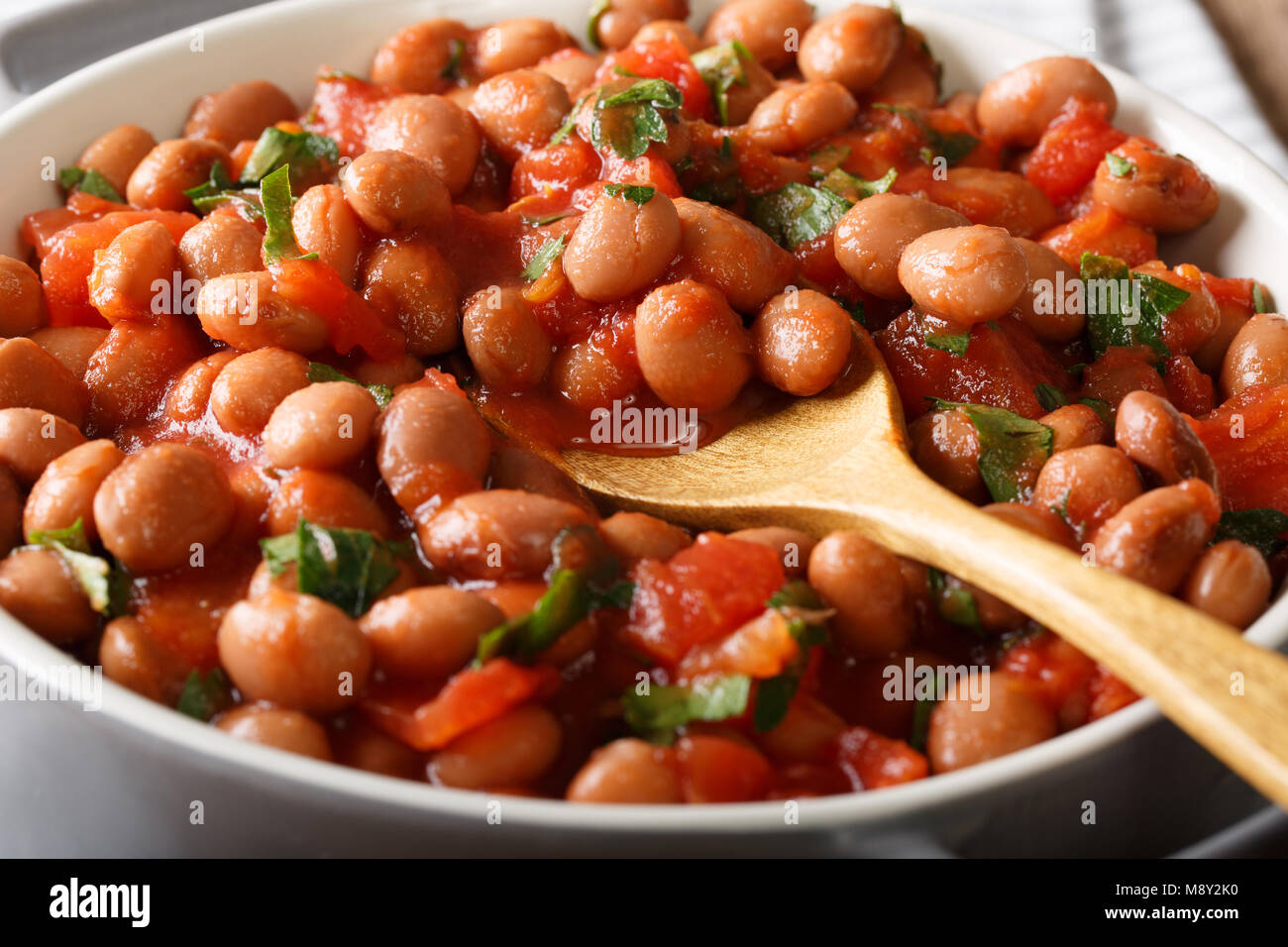 Cranberry Bohnen in Tomatensoße mit Kräutern close-up in einer Schüssel auf dem Tisch. Horizontale Stockfoto
