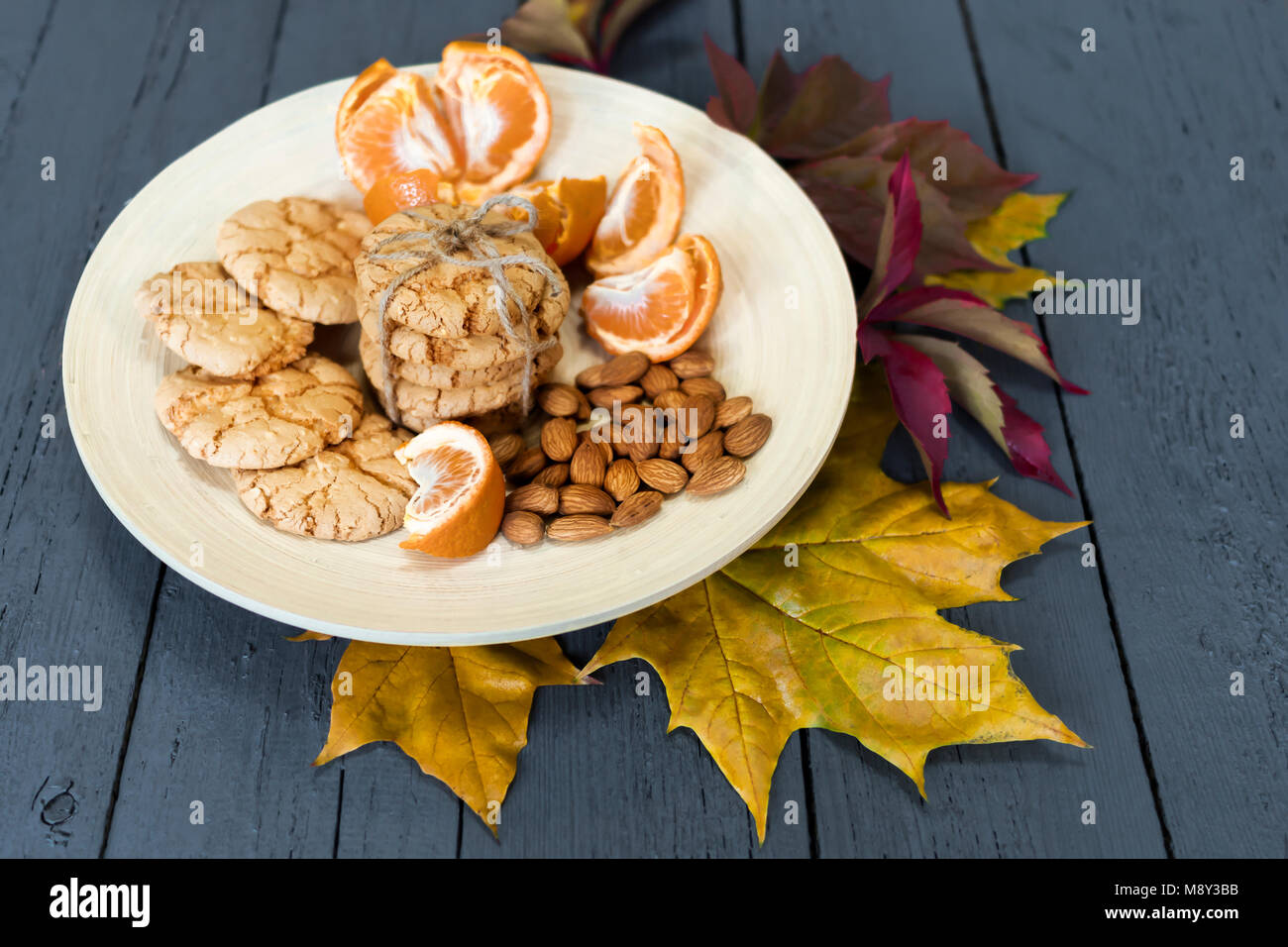 Almond Cookies auf einer Holzplatte mit Mandarinen Stockfoto