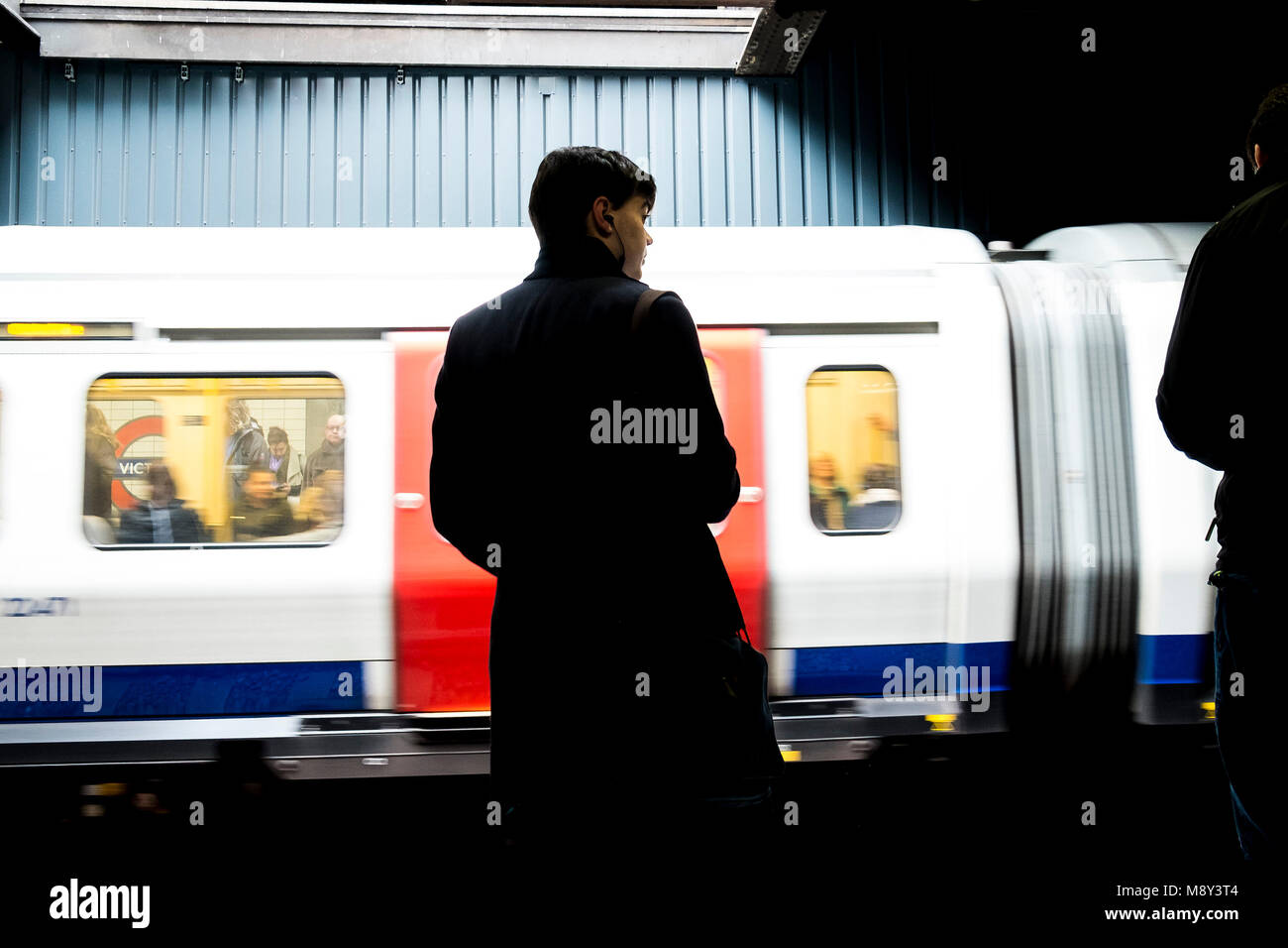 Ein pendler steht auf einer Plattform und warten auf eine U-Bahn zu erreichen. Stockfoto