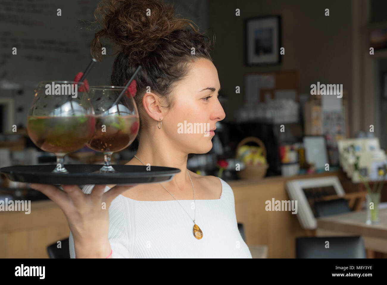 Eine Kellnerin bar Arbeitnehmer tragen ein Tablett mit Cocktails. Stockfoto