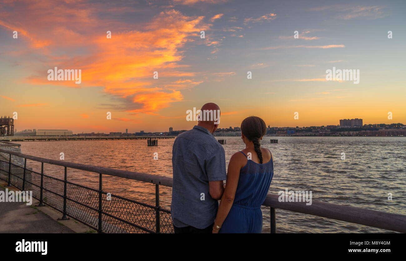 Paar beobachten, wunderschönen Sonnenuntergang im Riverside Park, Manhattan, NY Stockfoto