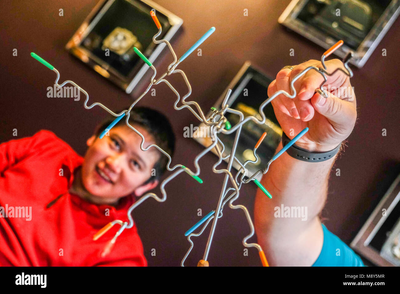 Ein autistischer Junge spielt Magnetische balancing Sticks mit einem Berater an einem Spiel Zimmer Stockfoto