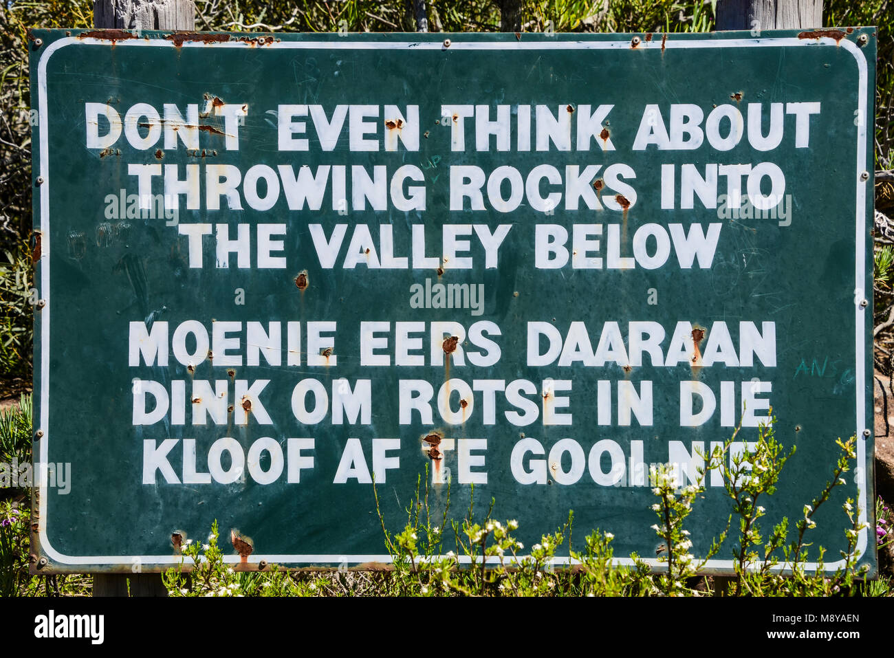 Ein Schild in Englisch und Afrikaans im Tal der Verwüstung, Südafrika, das liest noch nicht einmal an das Werfen Steine ins Tal denken Stockfoto
