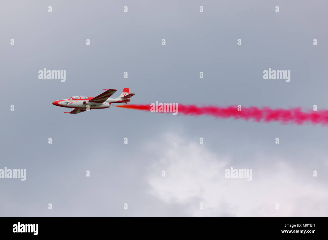 Die polnische Luftwaffe TS-11 Iskra Herr von White-Red Funken (Bialo-Czerwone Iskry) Kunstflug Team auf Fly mit roten Rauch während der International Air Show. Stockfoto