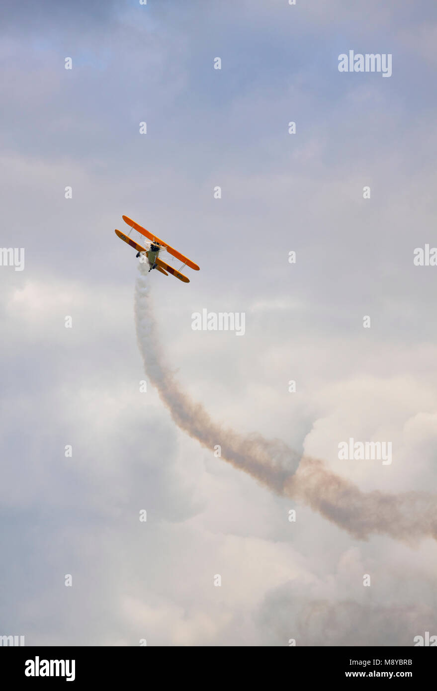 Die Boeing Stearman N2S-3 bis Fliegen über bewölkter Himmel während der International Air Show im 90. Jubiläumsjahr der polnischen Luftwaffe Akademie. Stockfoto