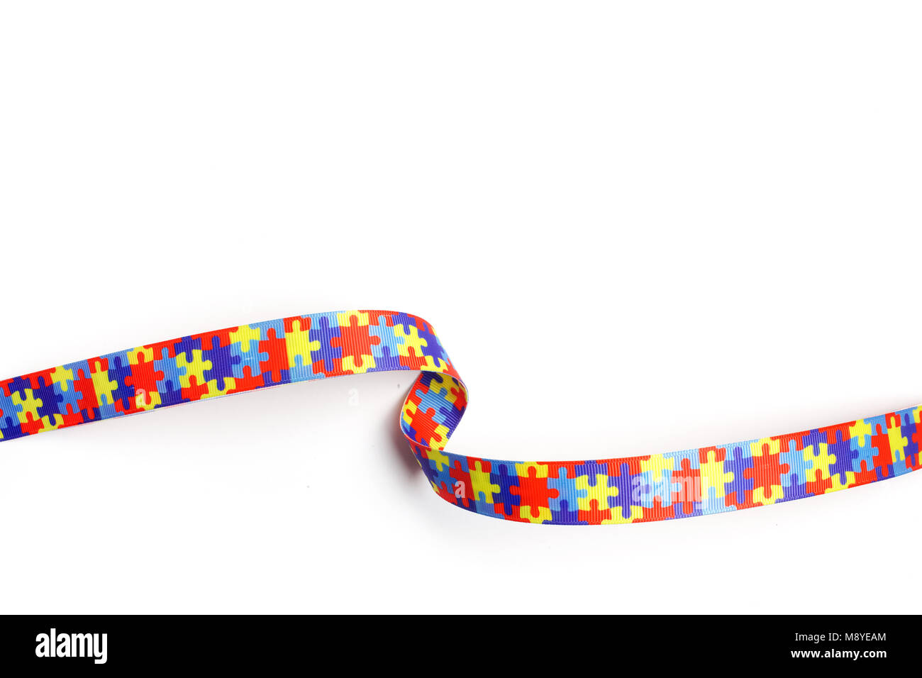 World Autism Bewußtsein und stolz Tag mit Puzzle Muster Band auf weißem Hintergrund Stockfoto