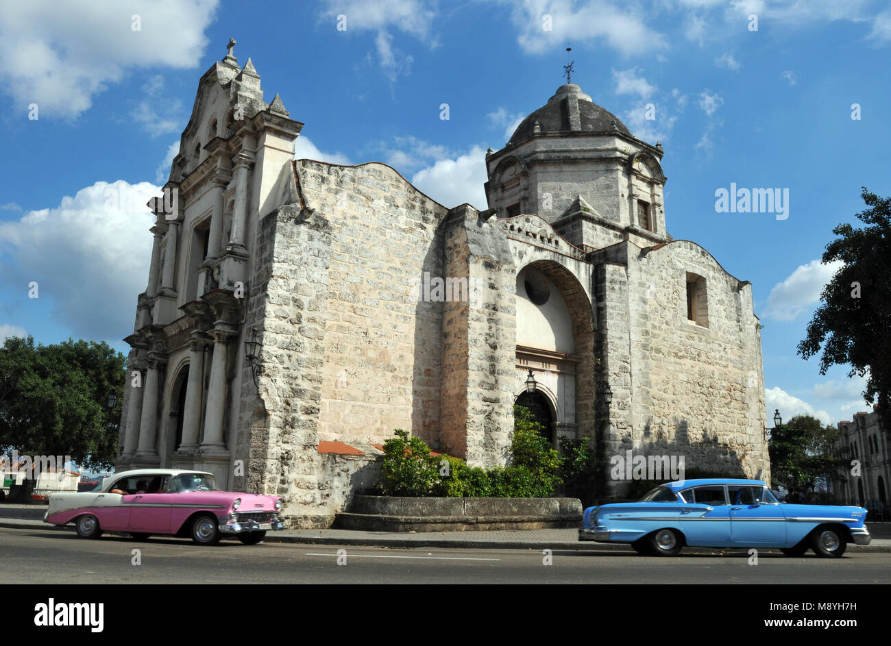 Bunte klassische Autos fahren vorbei an der historischen Iglesia de San Francisco de Paula (Kirche) in der Nähe der Waterfront in der Altstadt von Havanna, Kuba. Stockfoto