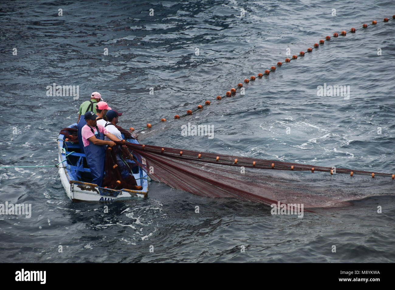 Fischer in einem kleinen Boot in Ihrer Net schleppen Stockfoto