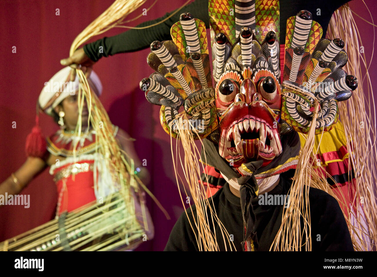 Traditionelle Sri Lankische Tänzer und Musiker an einem Display - in diesem Bild die Tänzerin ist das Tragen eines Raksha Maske - Verschlusszeit langsam, so Bewegungsunschärfe. Stockfoto