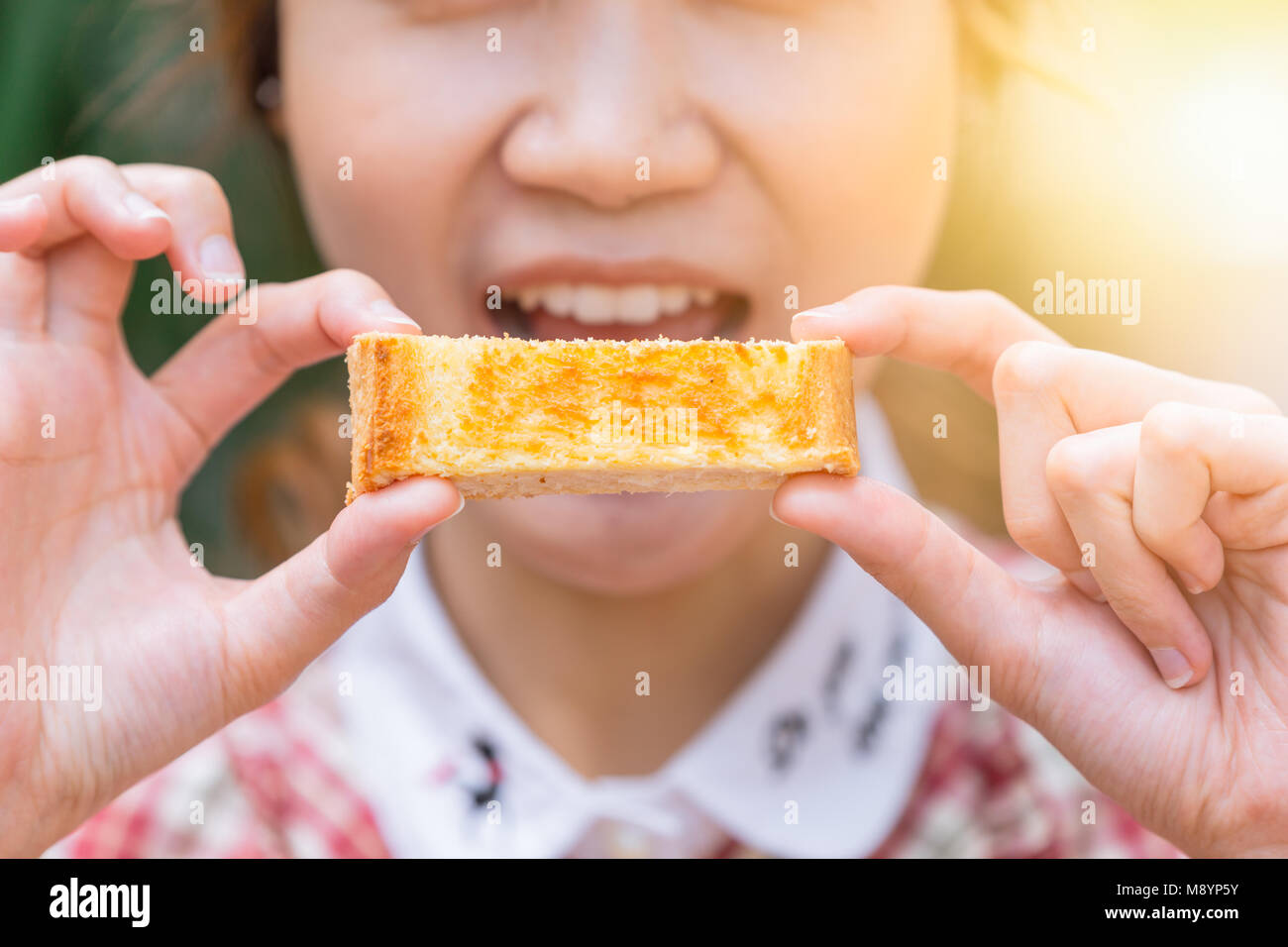 Nette Frauen, die sich in Butter toast Essen am Morgen closeup Stockfoto